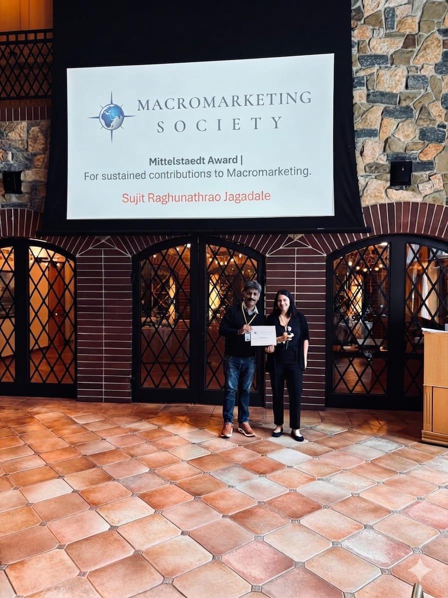 Dr. Sujit R. Jagadale receiving the Mittelstaedt Award beneath the Macromarketing Society banner